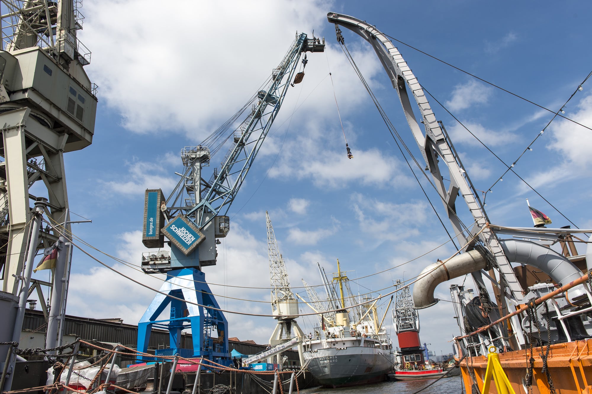 zwei Personen hängen in der Luft bei der Eröffnung des Hafenkrans für Bungee Springen im Hamburger Hafen